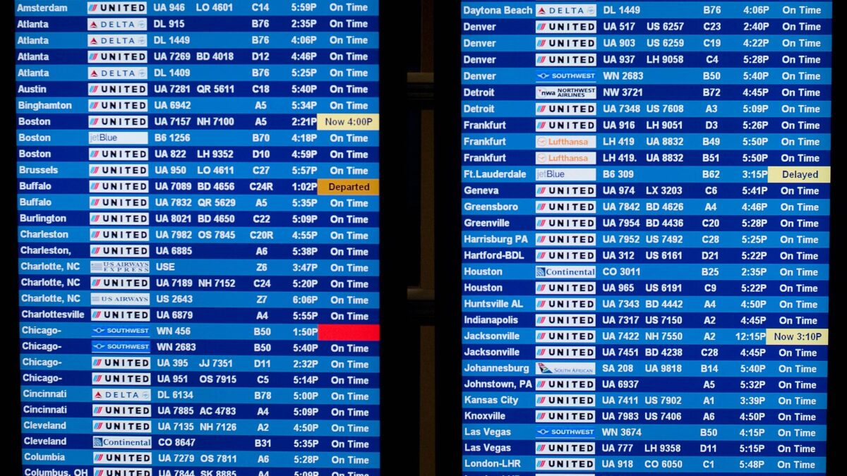 Airport departure board showing American, United and Southwest flights, including Chicago and Denver
