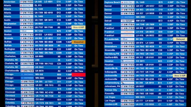 Airport departure board showing American, United and Southwest flights, including Chicago and Denver